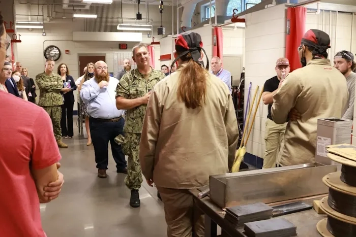 Man in fatigues talking to a group of people