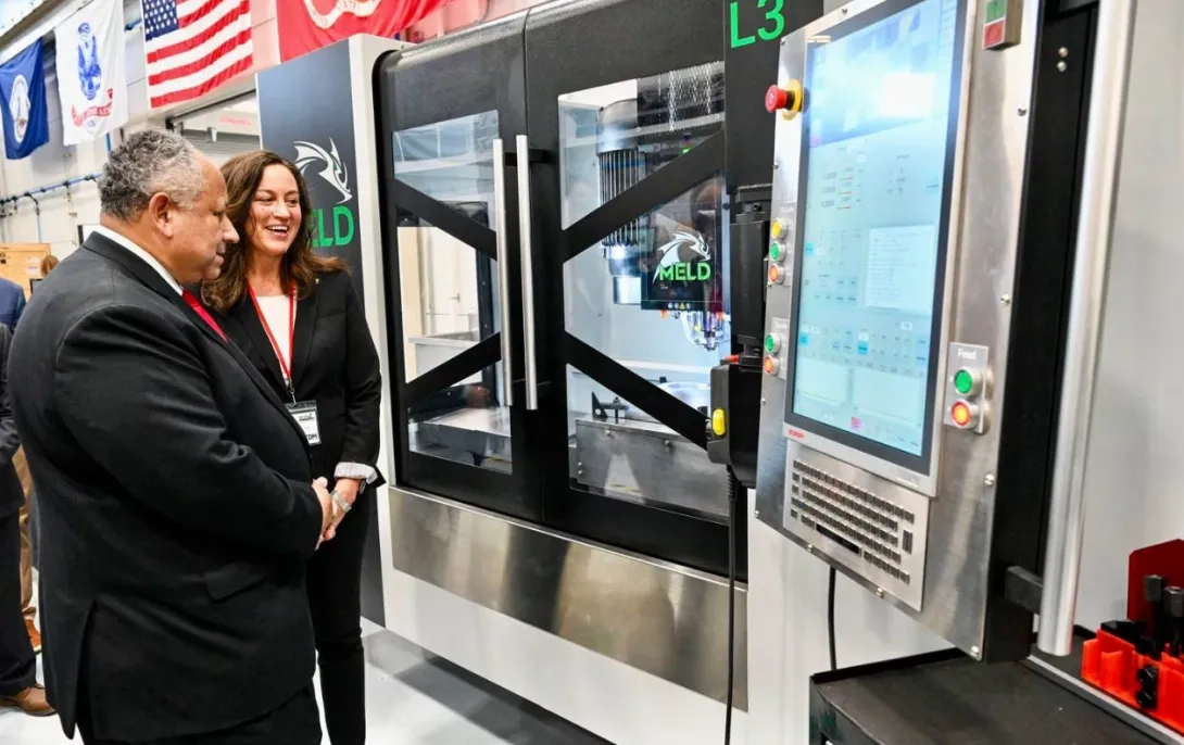 Two people standing in front of a display monitor