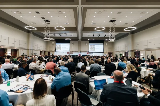 group of people in conference room sitting around large tables