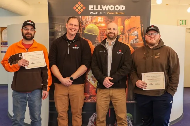 Group of four men, two holding certificates